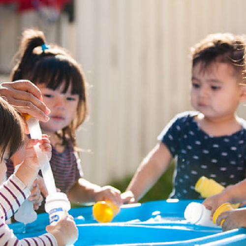Group of kids playing around a water table